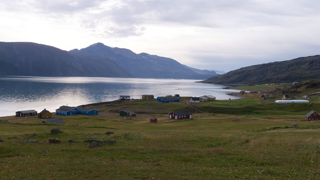 Marker og bygninger ved fjorden i Qassiarsuk